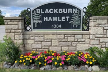 Flowers at Blackburn Hamlet Entrance Sign